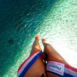 Low section of woman relaxing in swimming pool