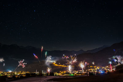 Low angle view of illuminated mountain against sky at night