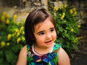 High angle view of girl smiling while looking away by plants