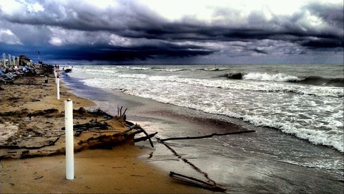 Scenic view of beach against cloudy sky