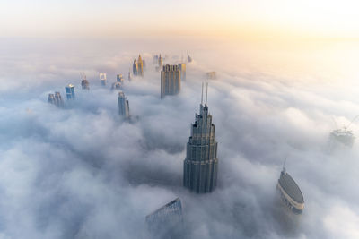 Aerial view of modern buildings against cloudy sky