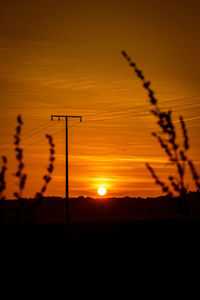 Scenic view of silhouette field against romantic sky at sunset