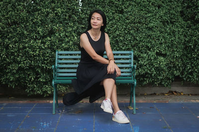 Young woman sitting on bench at park