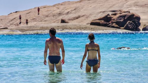 Rear view of couple standing in river