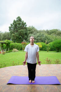Full length portrait of young man against trees