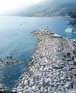 Pier of the touristic harbor of the sea village of camogli, liguria, italy that faces paradise bay