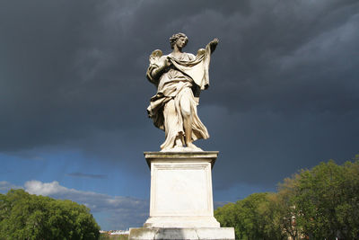 Low angle view of statue against cloudy sky