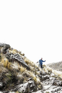 Man on land against clear sky