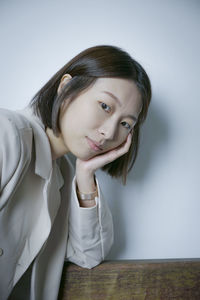 Portrait of young woman against white background