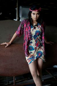 Beautiful young woman standing against wall