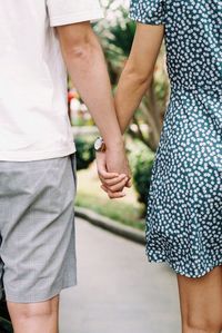 Midsection of couple holding hands