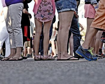 Low section of people standing on tiled floor