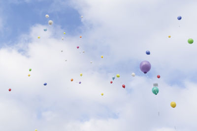 Low angle view of balloons flying against sky