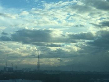 Low angle view of silhouette power lines against sky