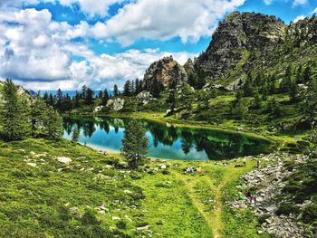 Scenic view of lake by trees against sky