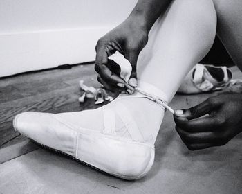 Low section of ballet dancer wearing shoe at studio
