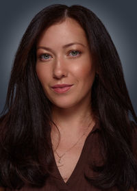 Portrait of young woman against black background