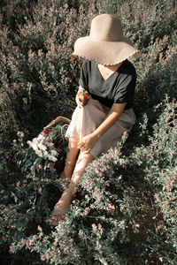 Rear view of woman sitting on field