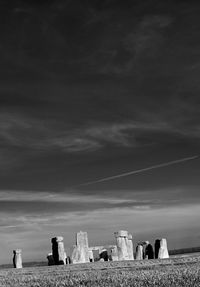 Statues on field against sky