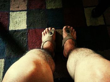 Low section of woman relaxing on tiled floor