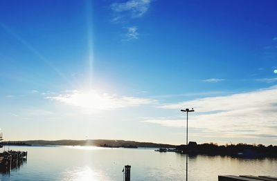 Scenic view of lake against blue sky on sunny day