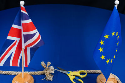 Close-up of flags with rope and scissors on table