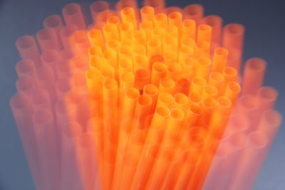 Double exposure of orange straws against blue background