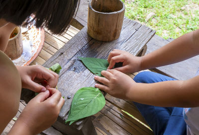 Children hands playing cooking with leaves at home.