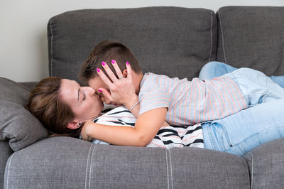 Low section of woman sitting on sofa at home