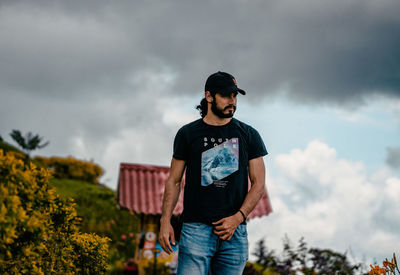 Rear view of man standing on field against sky