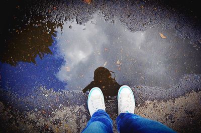 Low section of person standing in puddle