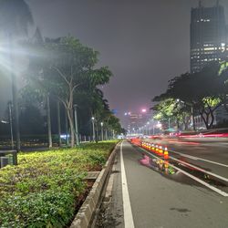 Cars on road against sky in city at night