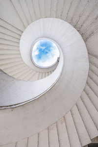 Spiral staircase and cloudy sky