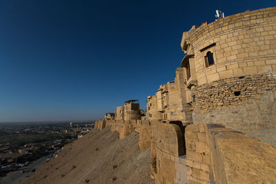 Ruins of building against clear blue sky