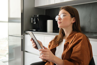 Young woman using mobile phone at home