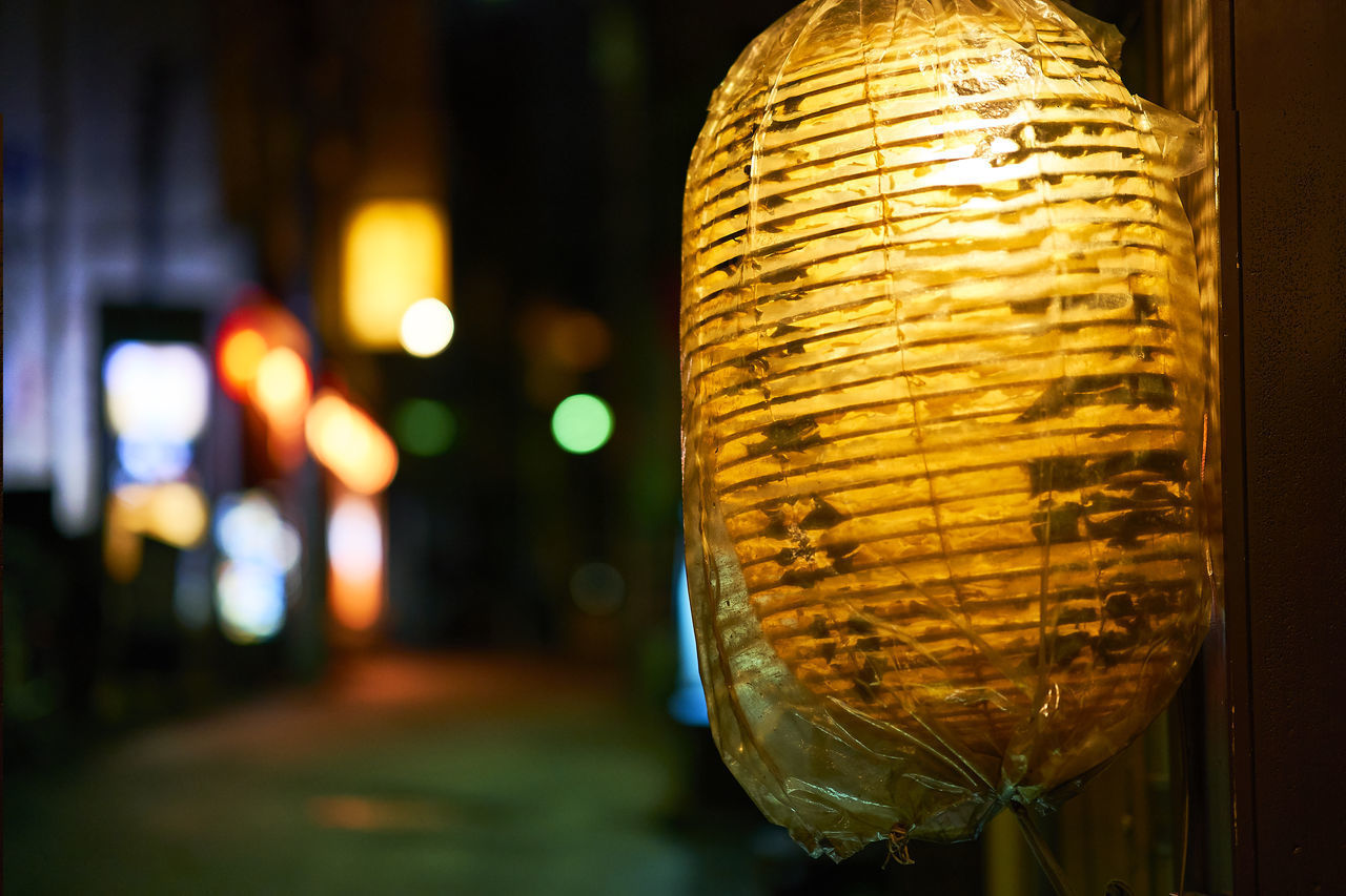 CLOSE-UP OF ILLUMINATED LANTERNS HANGING AT NIGHT