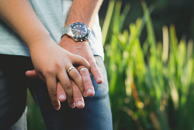 Midsection of man holding woman hand