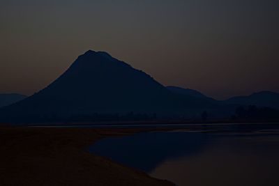 Scenic view of lake against clear sky during sunset