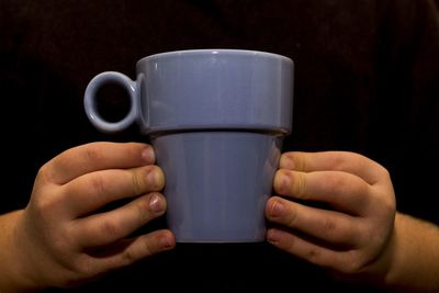 Close-up of hand holding coffee cup