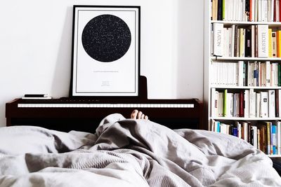 Low section of person relaxing on bed at home