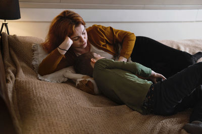 Middle age woman mother with son. female hugging her lovely teen child in bedroom in the evening