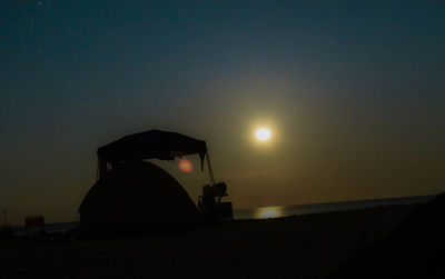 Silhouette people on beach against sky during sunset