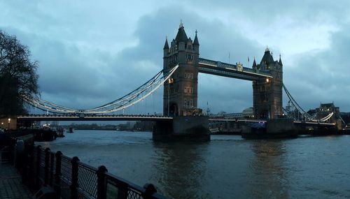 Bridge over river against cloudy sky