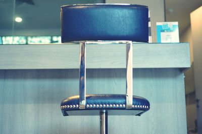 Close-up of empty chairs on table against wall