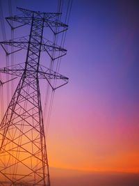 Low angle view of silhouette electricity pylon against romantic sky