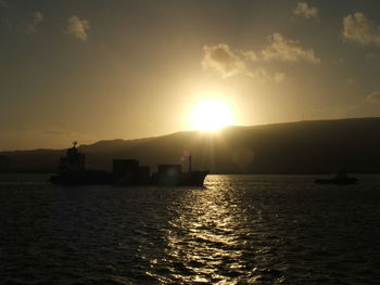 Boat sailing in sea at sunset