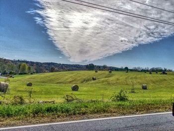 Hay bales on field against sky