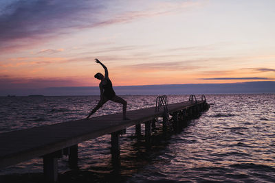 Young woman exercising yoga at sunrise in the morning outdoors