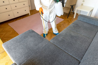 Low section of woman standing on tiled floor at home