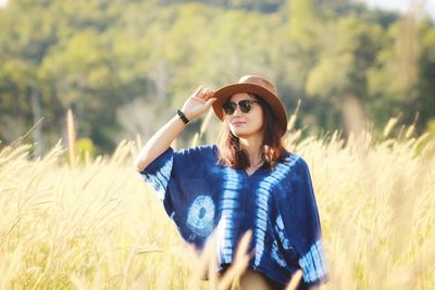 Smiling young woman standing on field